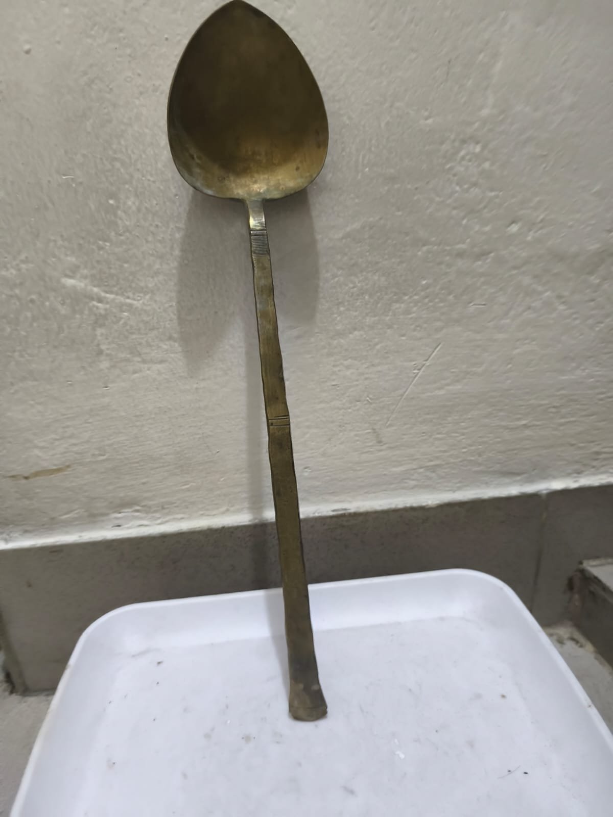 একটি পিতলের হাতা বা রান্নার চামচ।