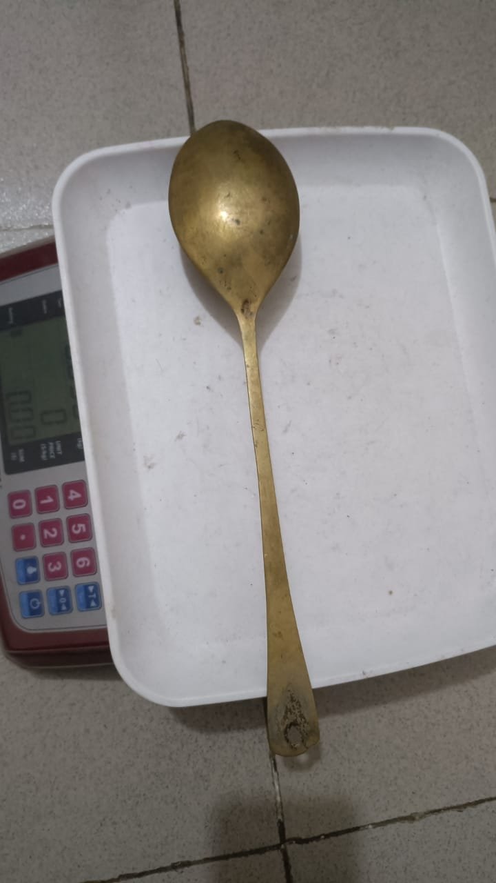 একটি পিতলের হাতা বা রান্নার চামচ।