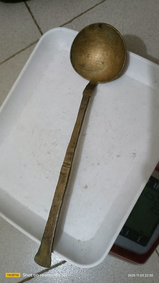 একটি পিতলের হাতা বা রান্নার চামচ।