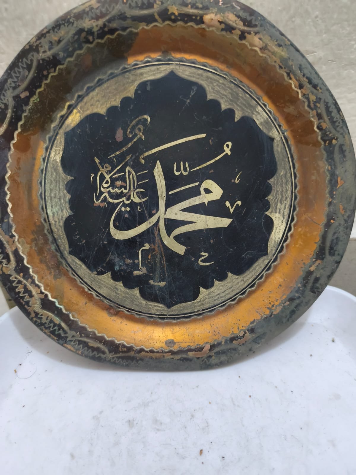 একটি আলংকারিক পিতলের প্লেট যাতে ইসলামী ক্যালিগ্রাফি রয়েছে