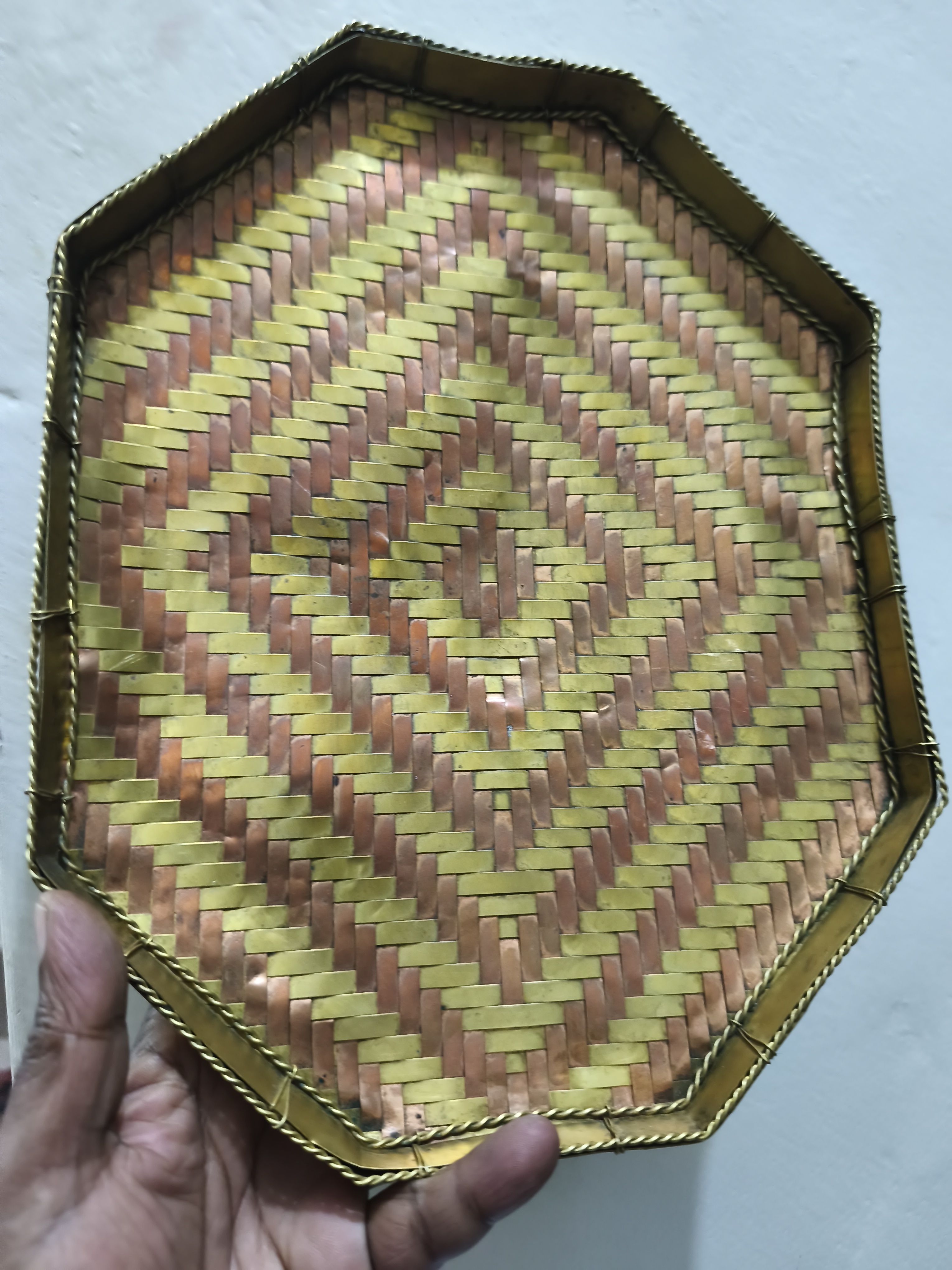 পিতল এবং তামার স্ট্রিপ দিয়ে তৈরি একটি বোনা ট্রে বা ঝুড়ি।