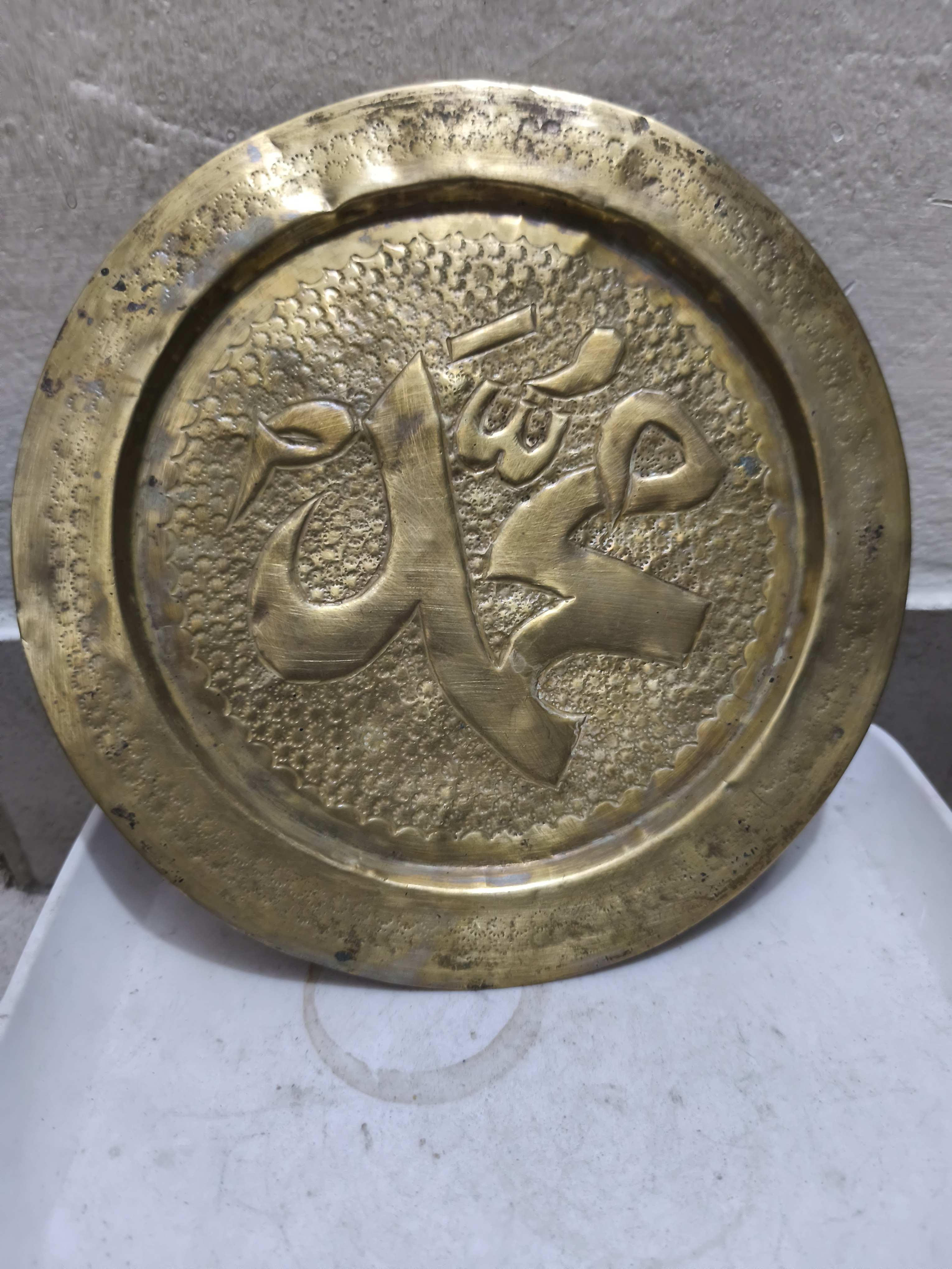 প্রাচীন পিতলের প্লেটে "মুহাম্মদ" নামের জটিল ইসলামী ক্যালিগ্রাফি রয়েছে