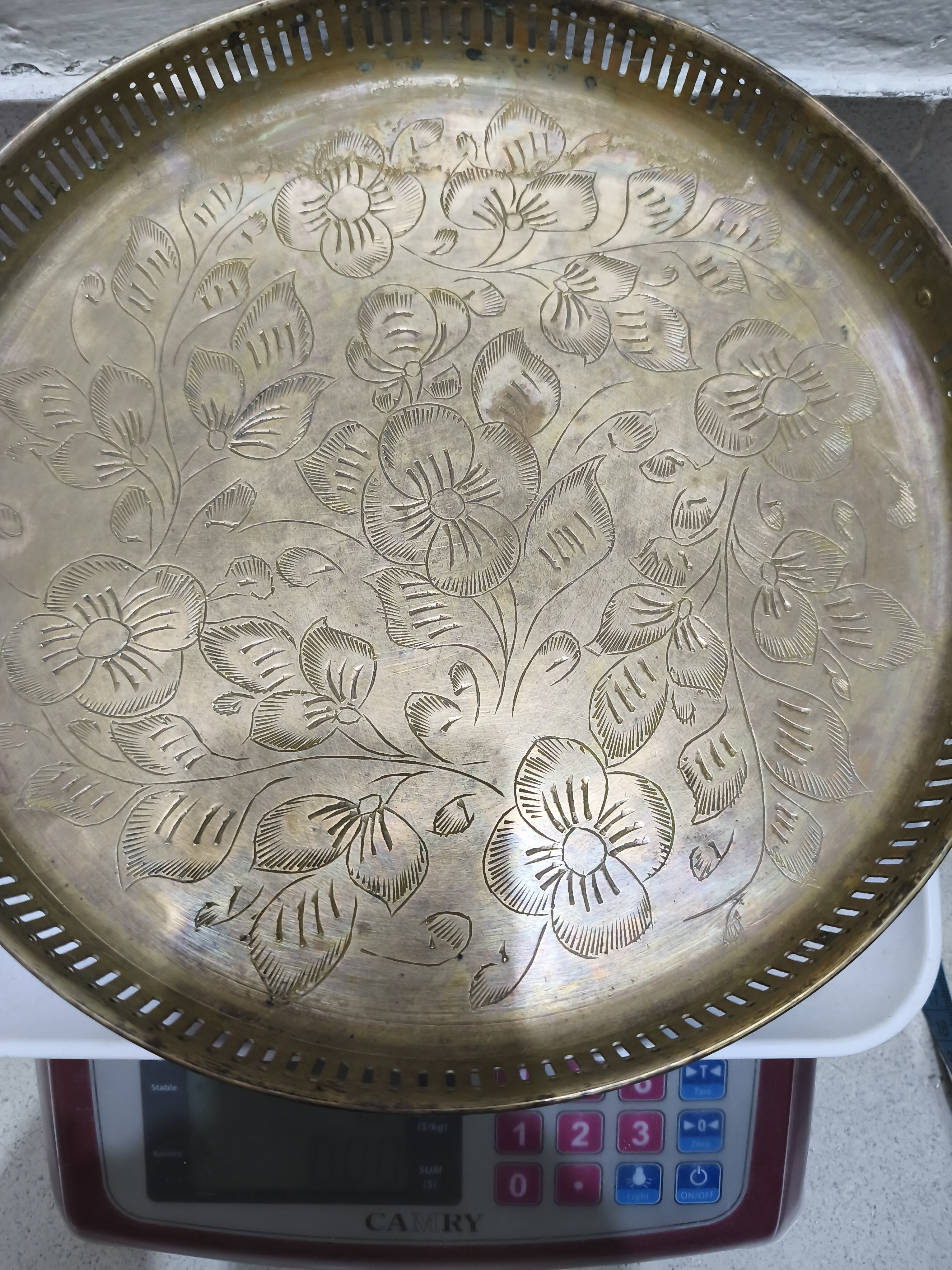 একটি সংগ্রহযোগ্য ভিনটেজ পিতলের পরিবেশন ট্রে বা আলংকারিক প্লেট যাতে জটিল হাতে খোদাই করা ফুলের নকশা